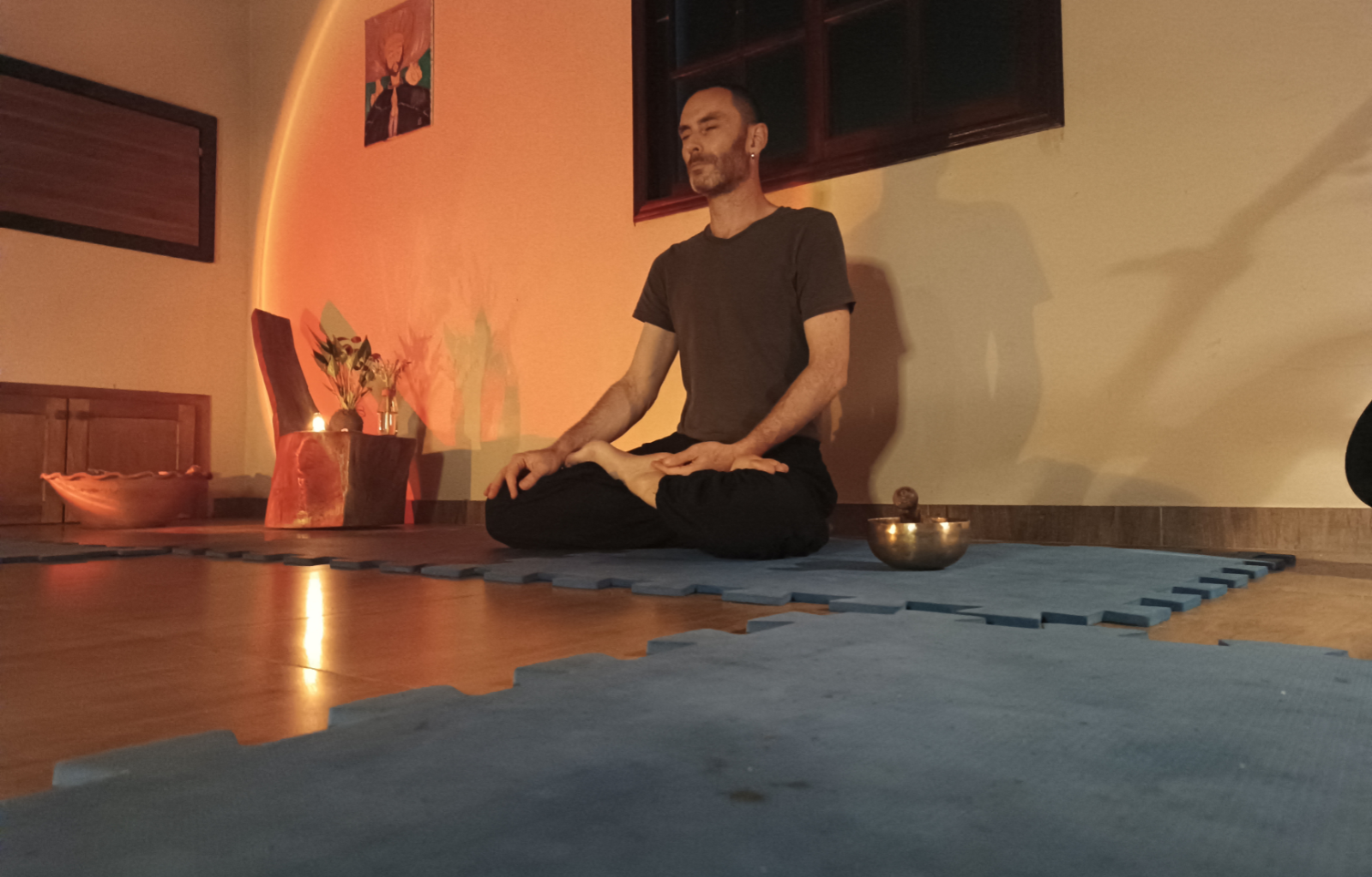 Imagem com o terapeuta Rodrigo Cainelli sentando em meditação na posição de lótus. Imagem registrada em um encontro de meditação conduzido pelo terapeuta.