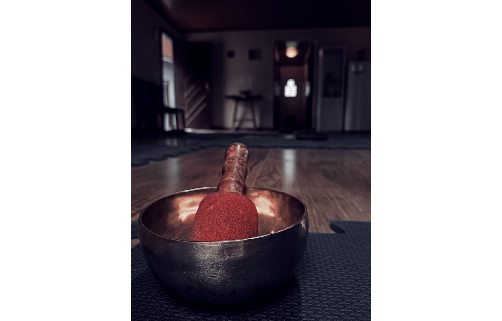 Imagem de uma tigela tibetana sobre um tatame com o fundo da sala em desfoque.